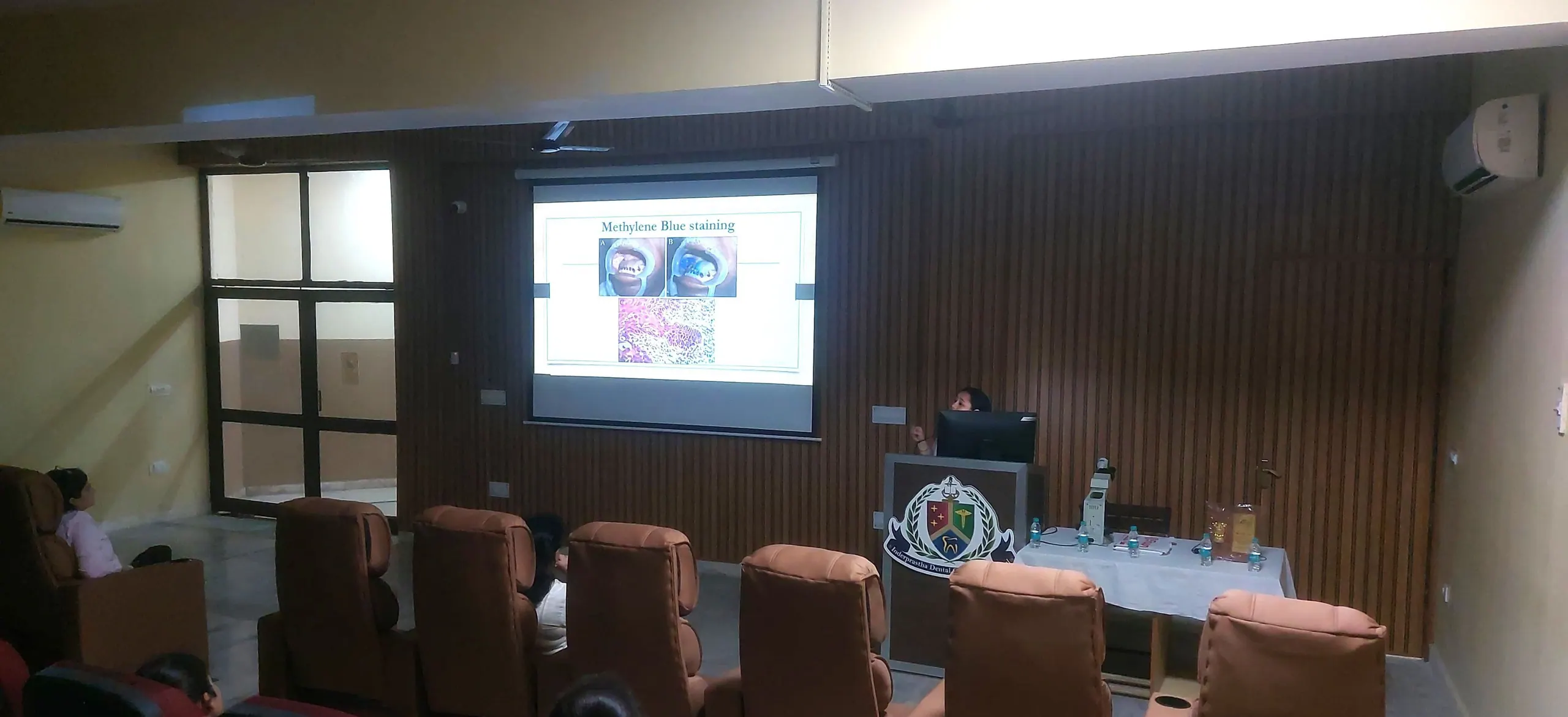 A lecture on early detection of oral cancer, with a microscope on the demonstration table