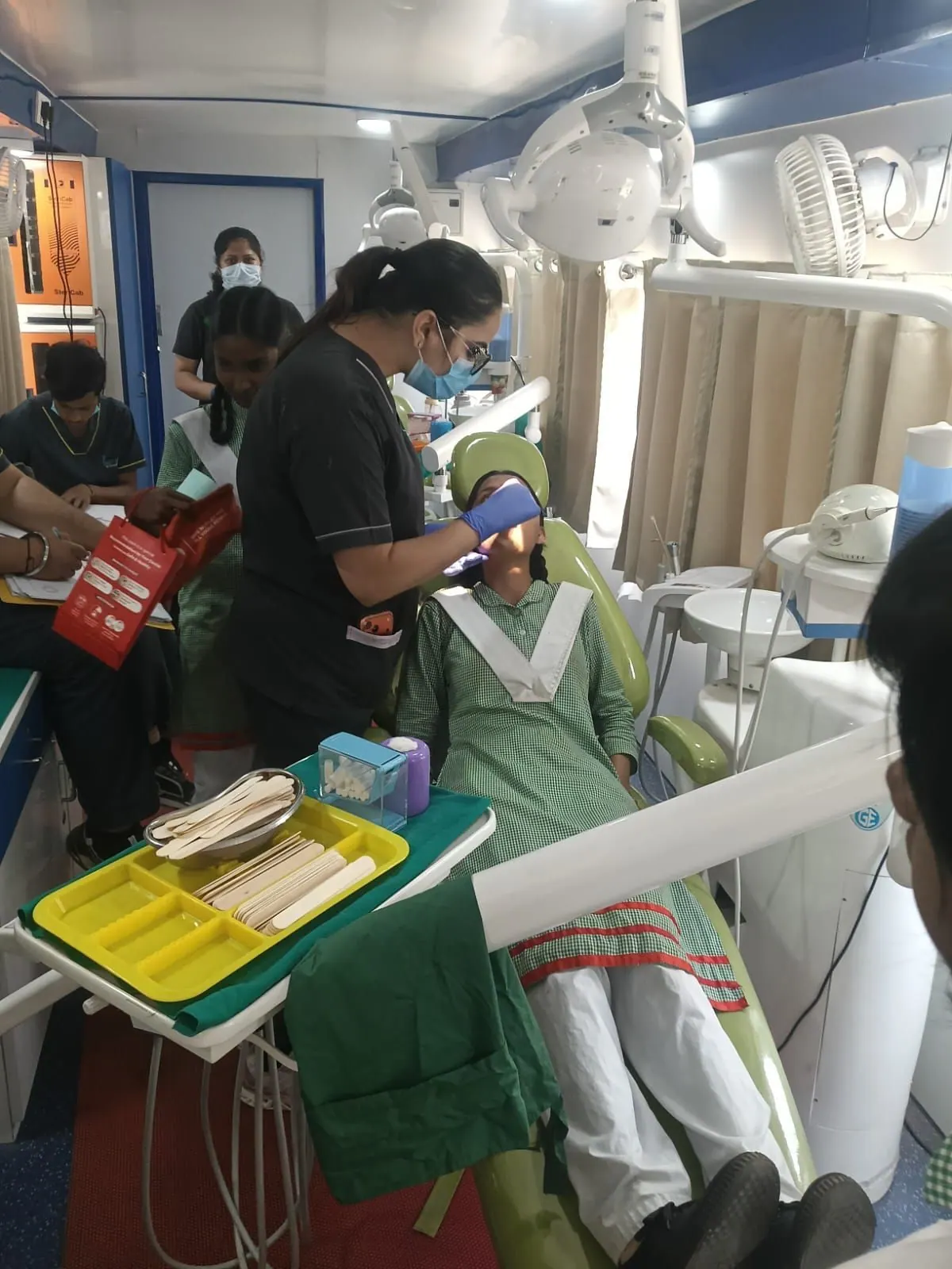Examining a student inside the van at a school camp, Department of Public Health Dentistry, Inderprastha Dental College